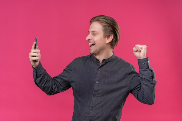 Young handsome man holding mobile phone