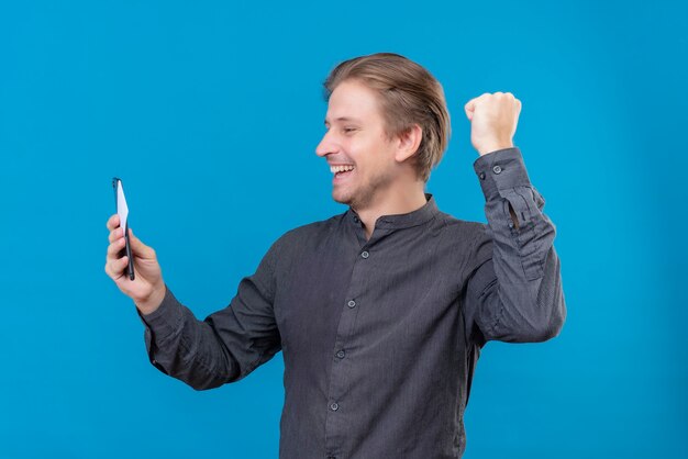 Young handsome man holding mobile phone