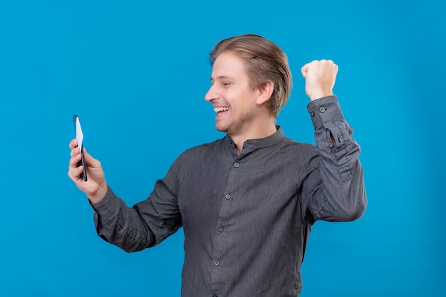 Young handsome man holding mobile phone