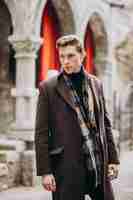 Бесплатное фото Молодой красивый мужчина в пальто за пределами улицы