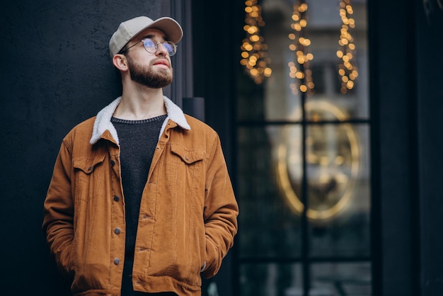 Young handsome man in jacket posing in the street in winter time