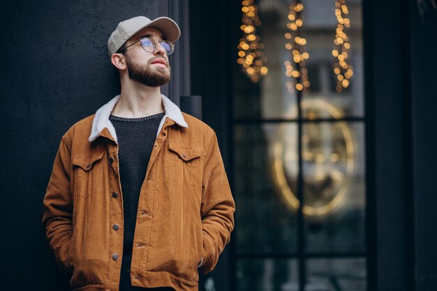 young handsome man in jacket posing in the street in winter time