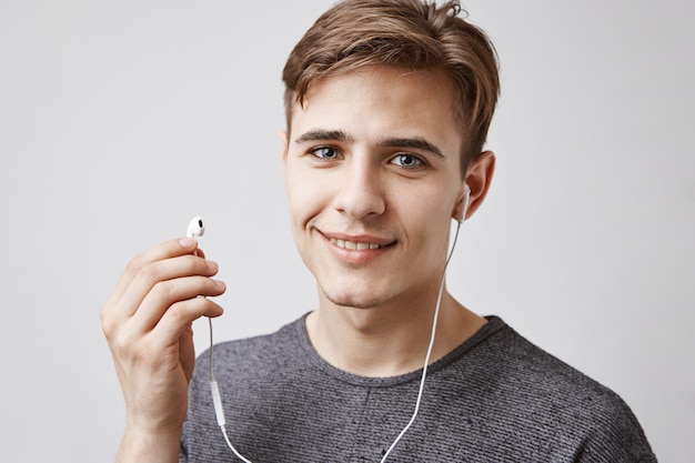 Young handsome man listens music with earphones