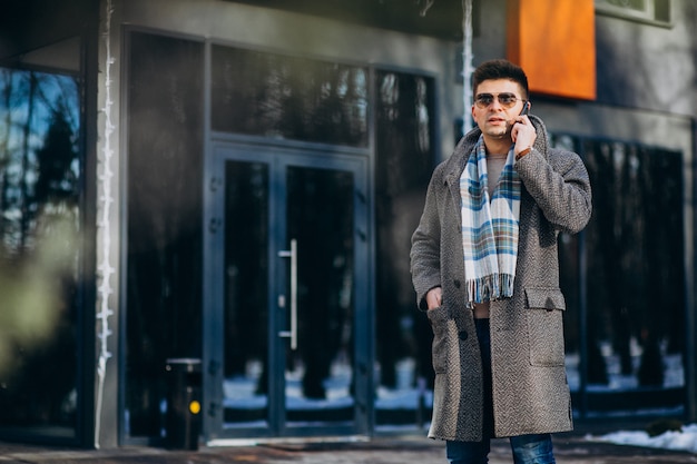 Young handsome man outside using phone