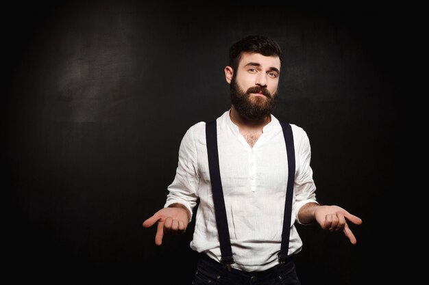 Young handsome man posing over black.