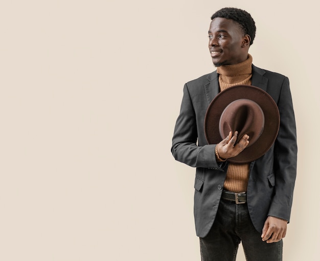 Free photo young handsome man posing with hat