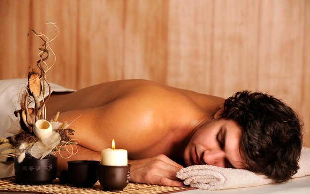 Young handsome man relaxing in spa salon - high angle view