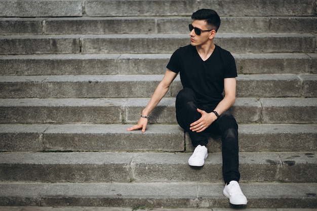 Young handsome man sitting on stairs