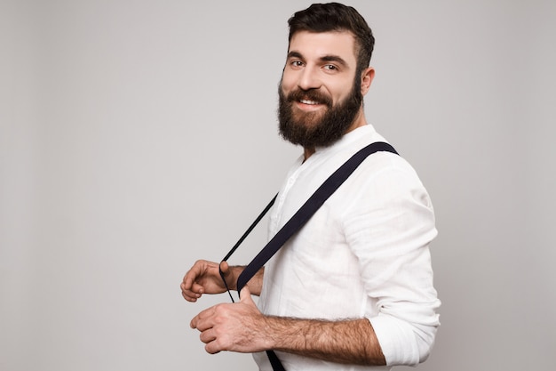 Young handsome man smiling posing over white.