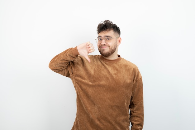 young handsome man standing and giving thumbs down. 