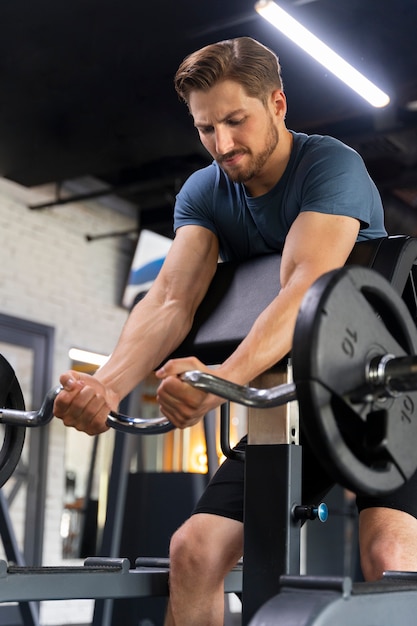 Free photo young handsome man training at the gym for bodybuilding