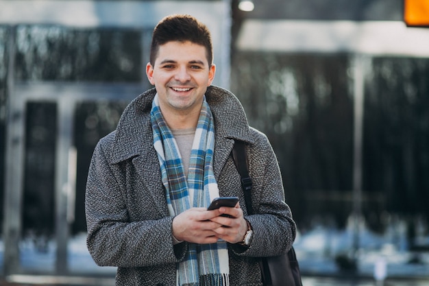 Young handsome man traveller using phone outside