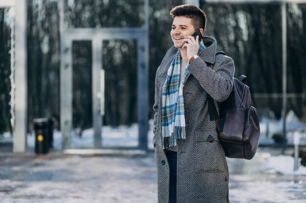 Young handsome man traveller using phone outside