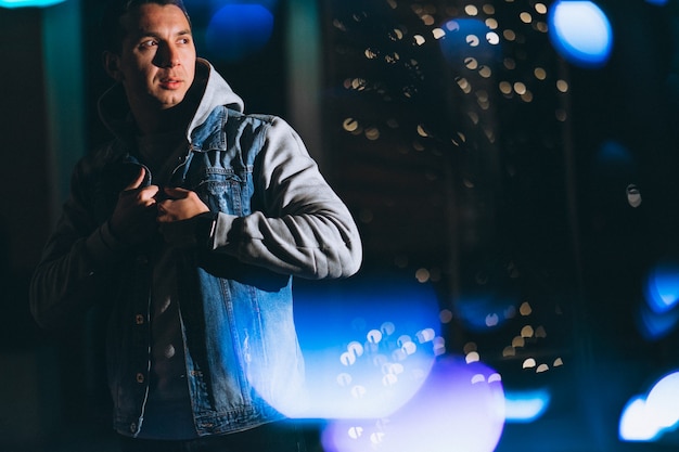 Young handsome man walking at evening outside the street