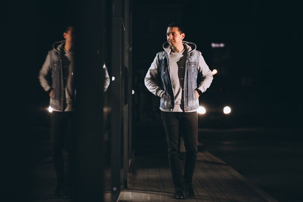 Young handsome man walking at evening outside the street