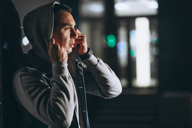 Young handsome man walking at evening outside the street