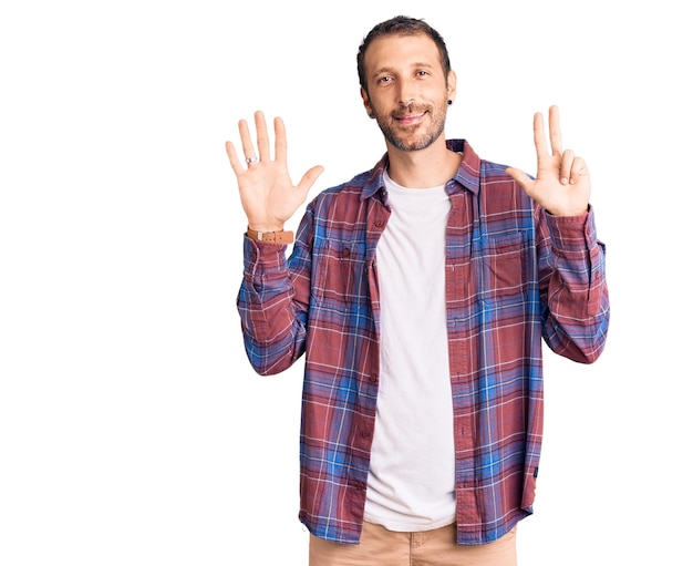 Young handsome man wearing casual clothes showing and pointing up with fingers number eight while smiling confident and happy.