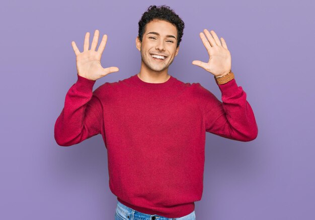 Young handsome man wearing casual clothes showing and pointing up with fingers number ten while smiling confident and happy.