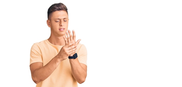 Free photo young handsome man wearing casual clothes suffering pain on hands and fingers, arthritis inflammation