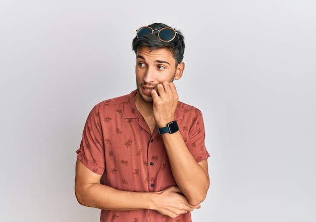 Free photo young handsome man wearing casual summer clothes looking stressed and nervous with hands on mouth biting nails. anxiety problem.