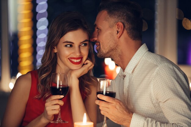 Young handsome man whisper to his woman while have romantic dinner