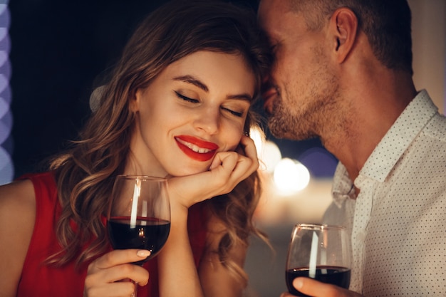 Free photo young handsome man whisper to his woman while have romantic dinner