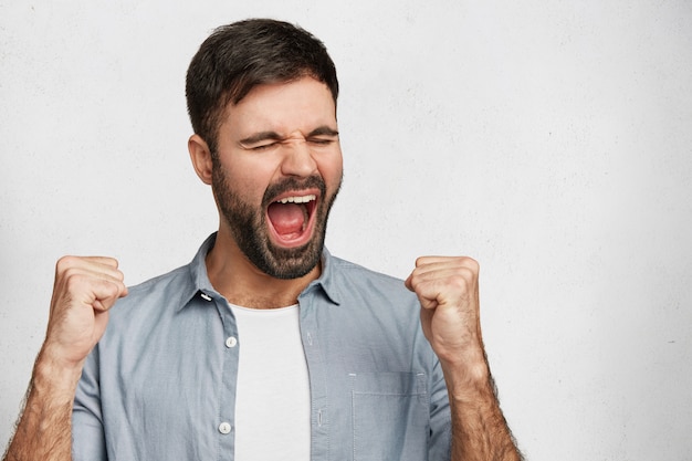 Foto gratuita giovane uomo bello con la camicia blu