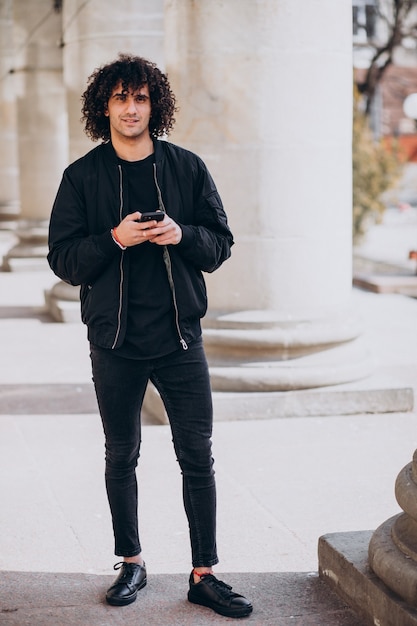 Young handsome man with curly hair talking on the phone