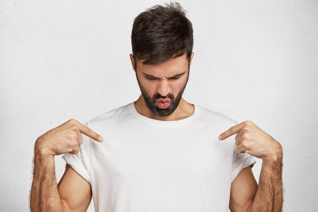 白いtシャツを持つ若いハンサムな男