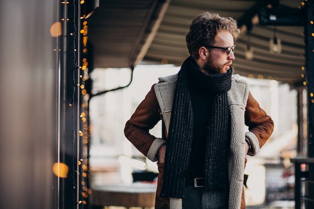 Young handsome man with winter clothes walking on street