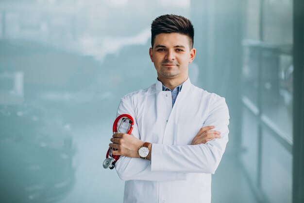 Young handsome physician in a medical robe with stethoscope