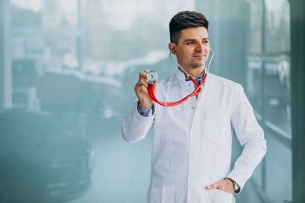 Young handsome physician in a medical robe with stethoscope