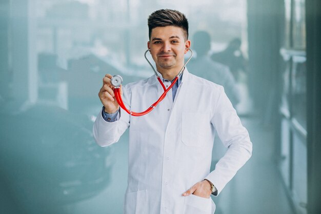 Young handsome physician in a medical robe with stethoscope