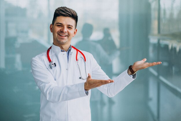 Young handsome physician in a medical robe with stethoscope