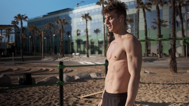 シティビーチでのトレーニングで若いハンサムなスポーティな筋肉の男