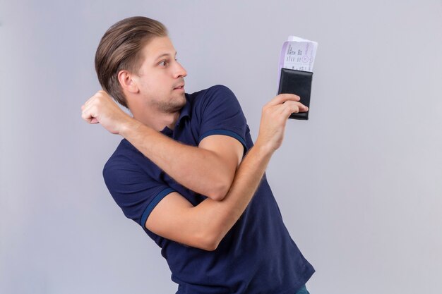 Young handsome traveler man holding air tickets looking away with confident look standing over white background