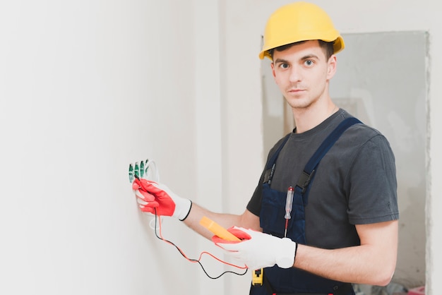 Young handyman measuring voltage