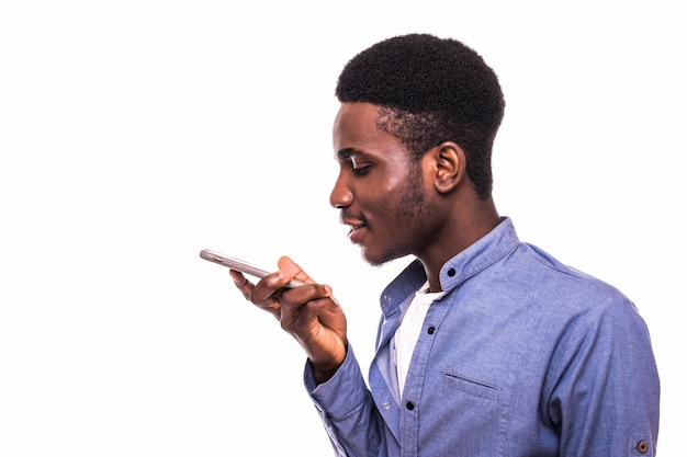 흰 벽에 고립 된 핸드폰을 말하는 젊은 행복 한 아프리카 사람