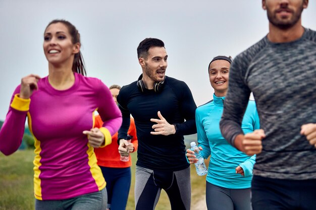 Young happy athletic couple running marathon an talking to each other