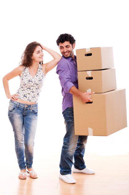 若くて幸せなカップルは箱を運ぶ