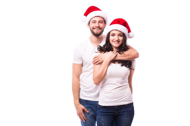 クリスマスの帽子をかぶった若い幸せなカップル。白い背景の上に分離