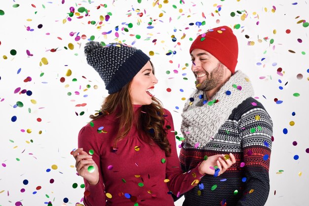 Young happy couple dresses with winter clothes on white background 