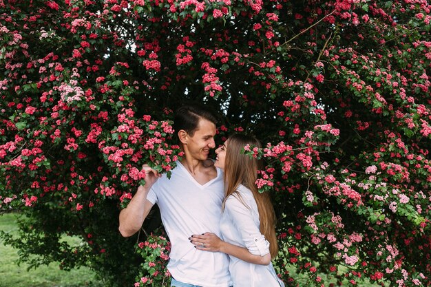 Young happy couple in love outdoors. loving man and woman on a walk in a spring blooming park