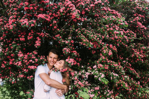 Young happy couple in love outdoors. loving man and woman on a walk in a spring blooming park