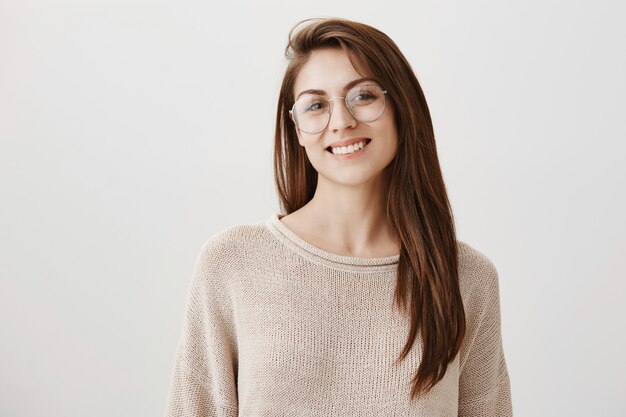 うれしそうな笑顔のメガネの若い幸せな女子学生