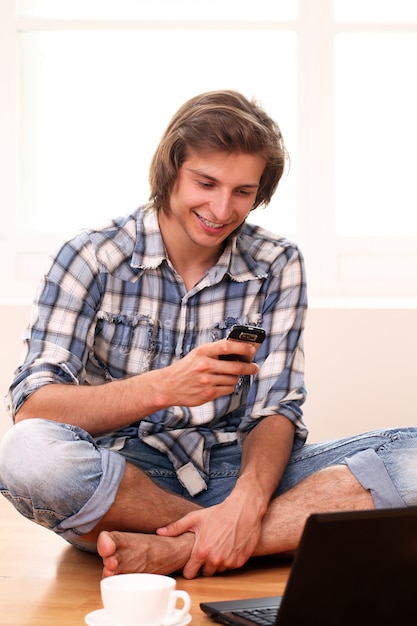 Young and happy guy using cellphone