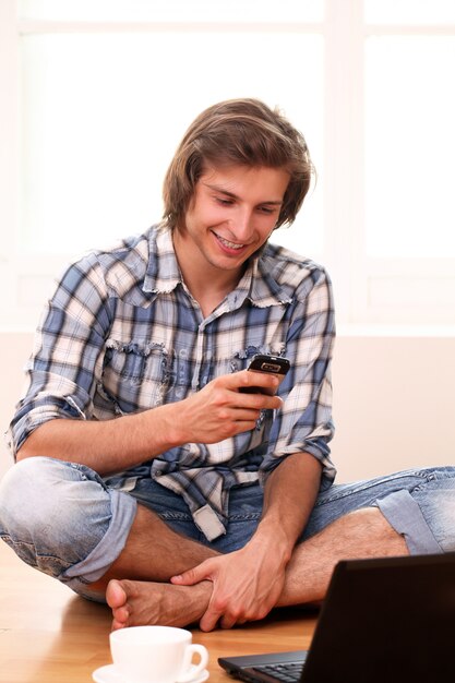 Young and happy guy using cellphone