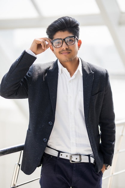 Young happy indian business man standing in office