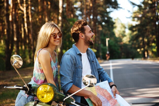 Young happy loving couple holding map outdoors