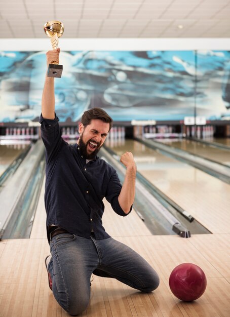 Young happy man after winning at bowling